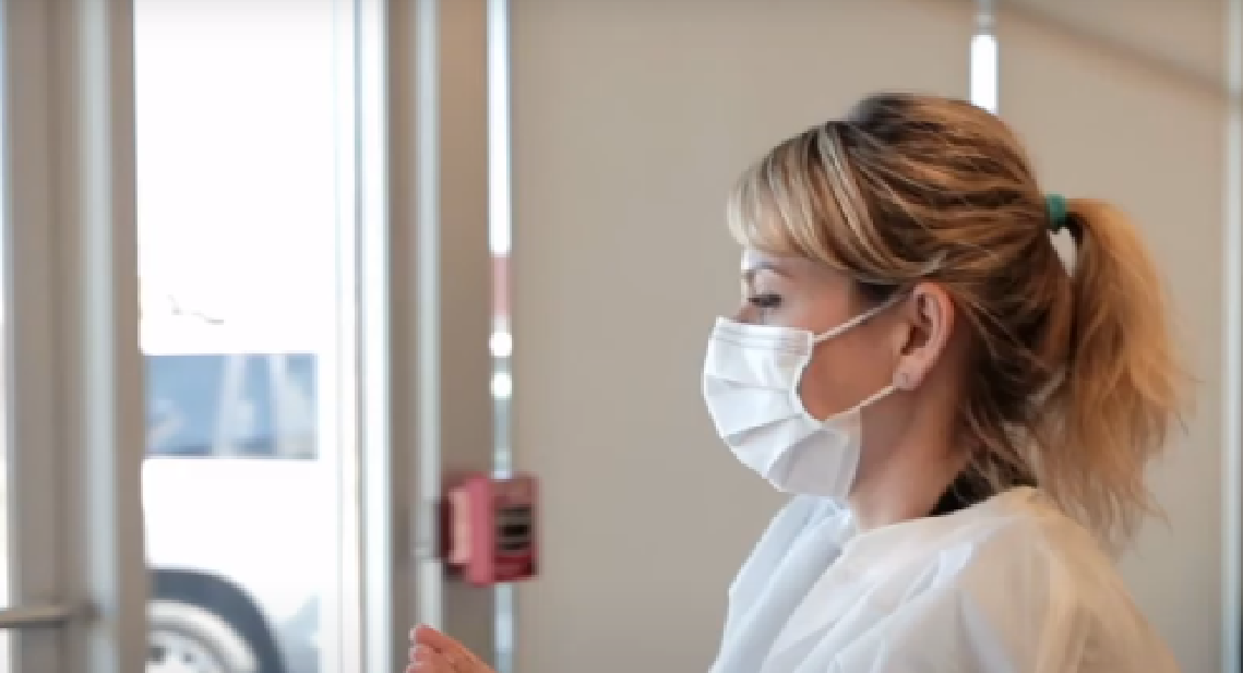 Dental staff following safety protocols while opening the door